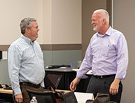 Two men smiling and talking to each other. Links to Gifts of Real Estate