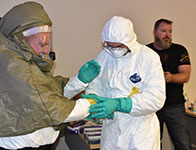 Photo of people suiting up in hazmat gear. Link to Gifts of Life Insurance